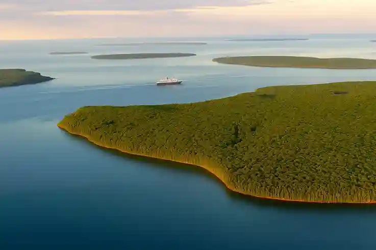 Cruise Ship Among the Apostle Islands An aerial view of the Apostle Islands in Lake Superior with a cruise ship sailing peacefully among the forested islands at sunset.