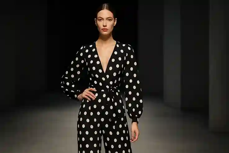 A stylish model wearing a contemporary polka dot outfit walks a modern runway under soft lighting, blending classic charm with modern fashion.