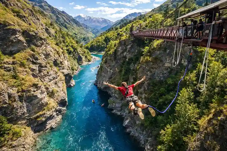 Traveler bungee jumping over a scenic canyon, capturing the thrill of dream vacation destinations.